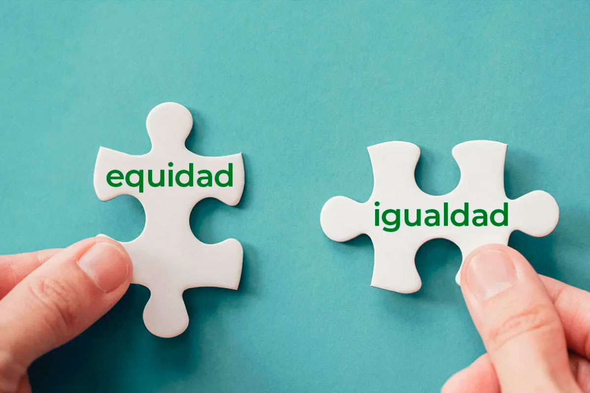 Dos manos sostienen dos piezas de rompecabezas blancas sobre un fondo turquesa. La pieza de la izquierda tiene escrita la palabra "equidad" en verde, y la de la derecha la palabra "igualdad". Las piezas están a punto de ser unidas.